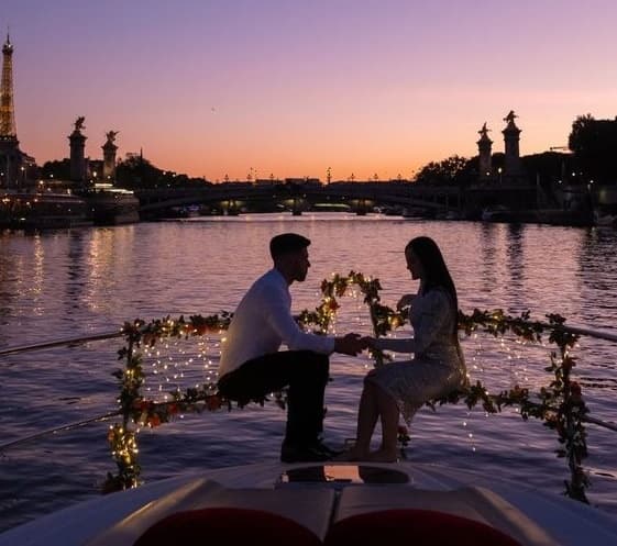 Couple on decorated boat at riverfront sunset romance cruise