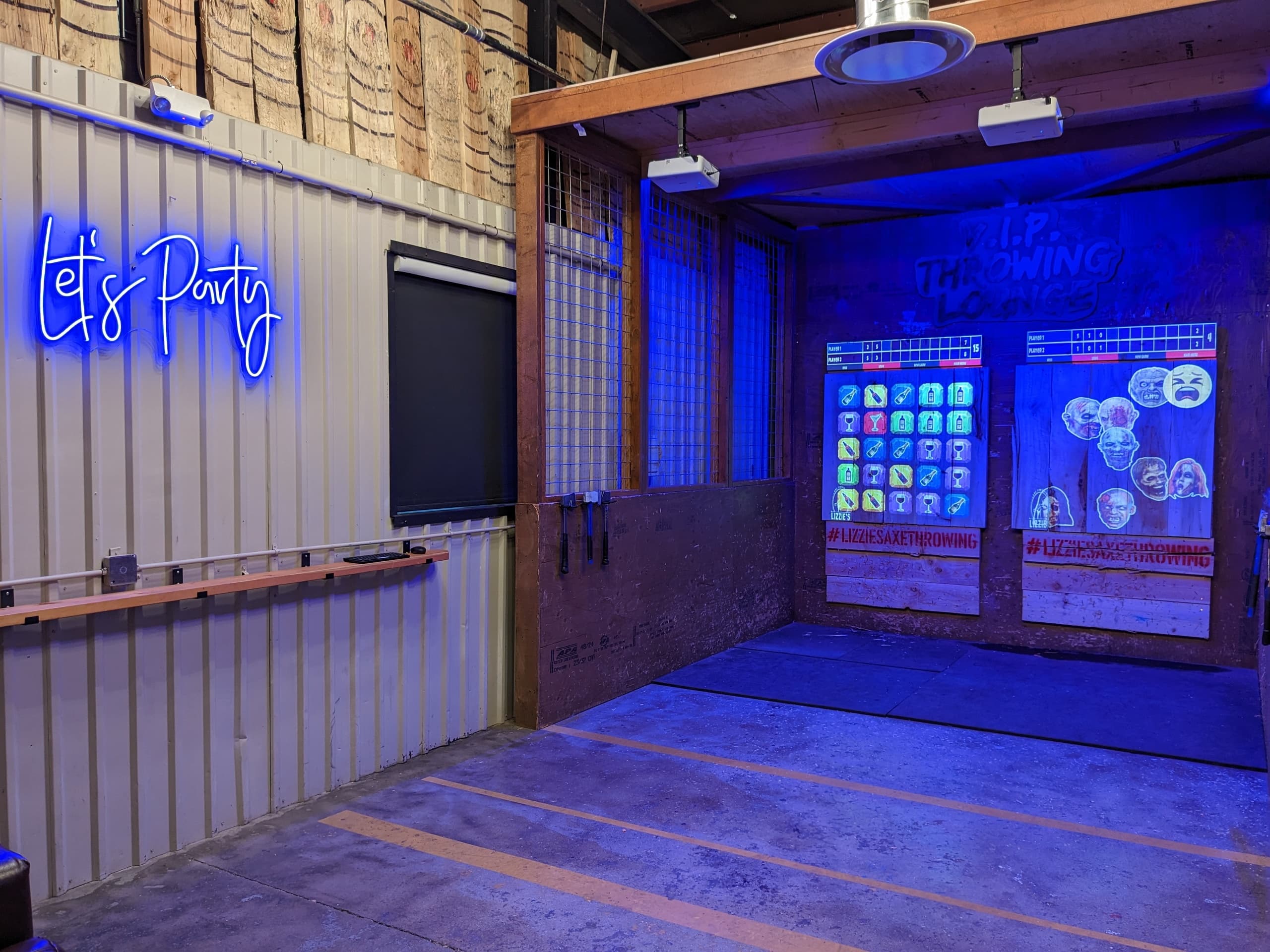 Indoor axe throwing lane with neon sign, empty throwing bay