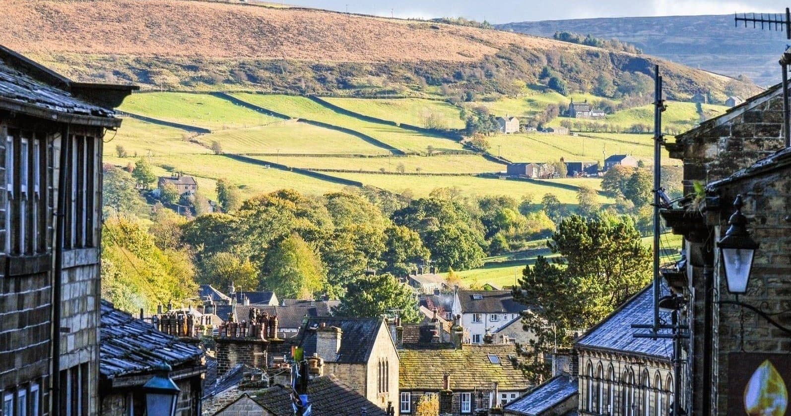 Historic stone town rooftops with rolling valley views ideal for walks