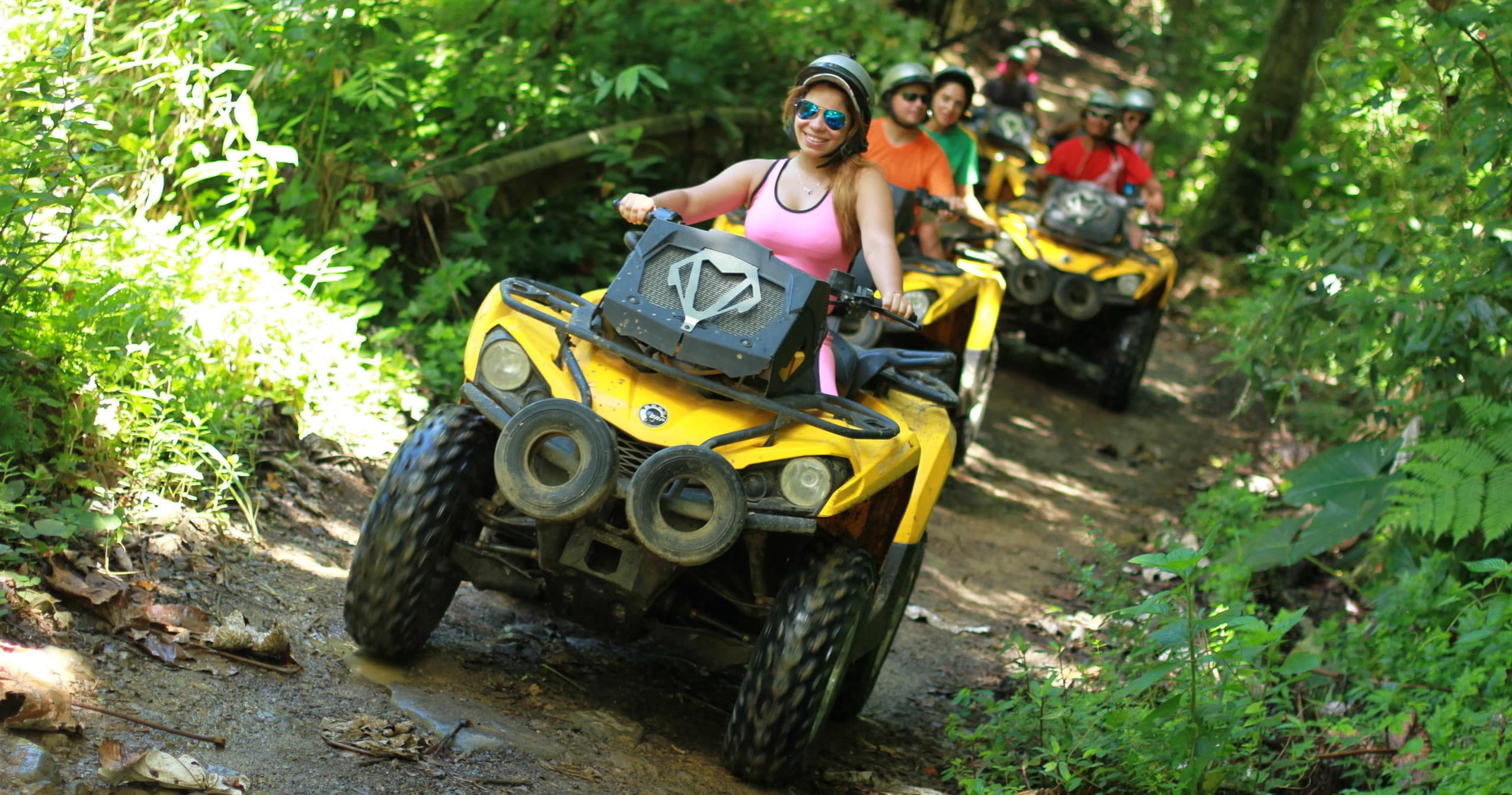 Yellow ATVs powering through dense jungle trail, off-road ride