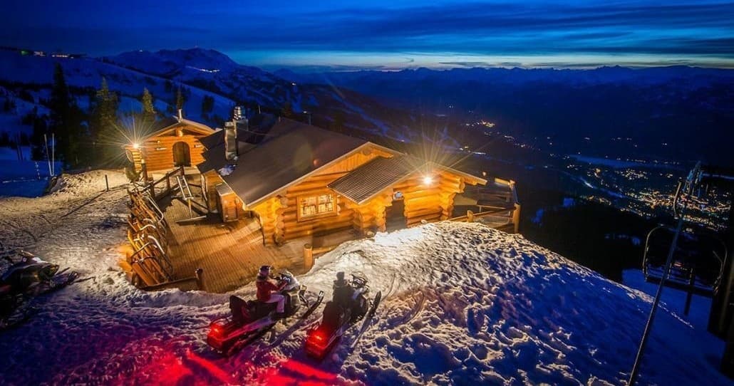 Snow-covered mountain lodge illuminated at dusk, alpine resort