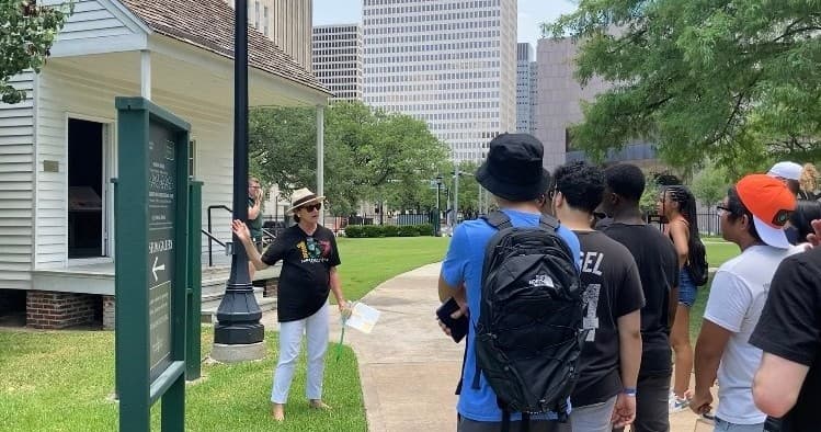 Guided walking tour group on historic house grounds in Houston