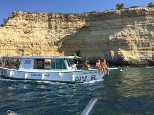 Coastal sightseeing boat beside limestone cliffs, ocean tour
