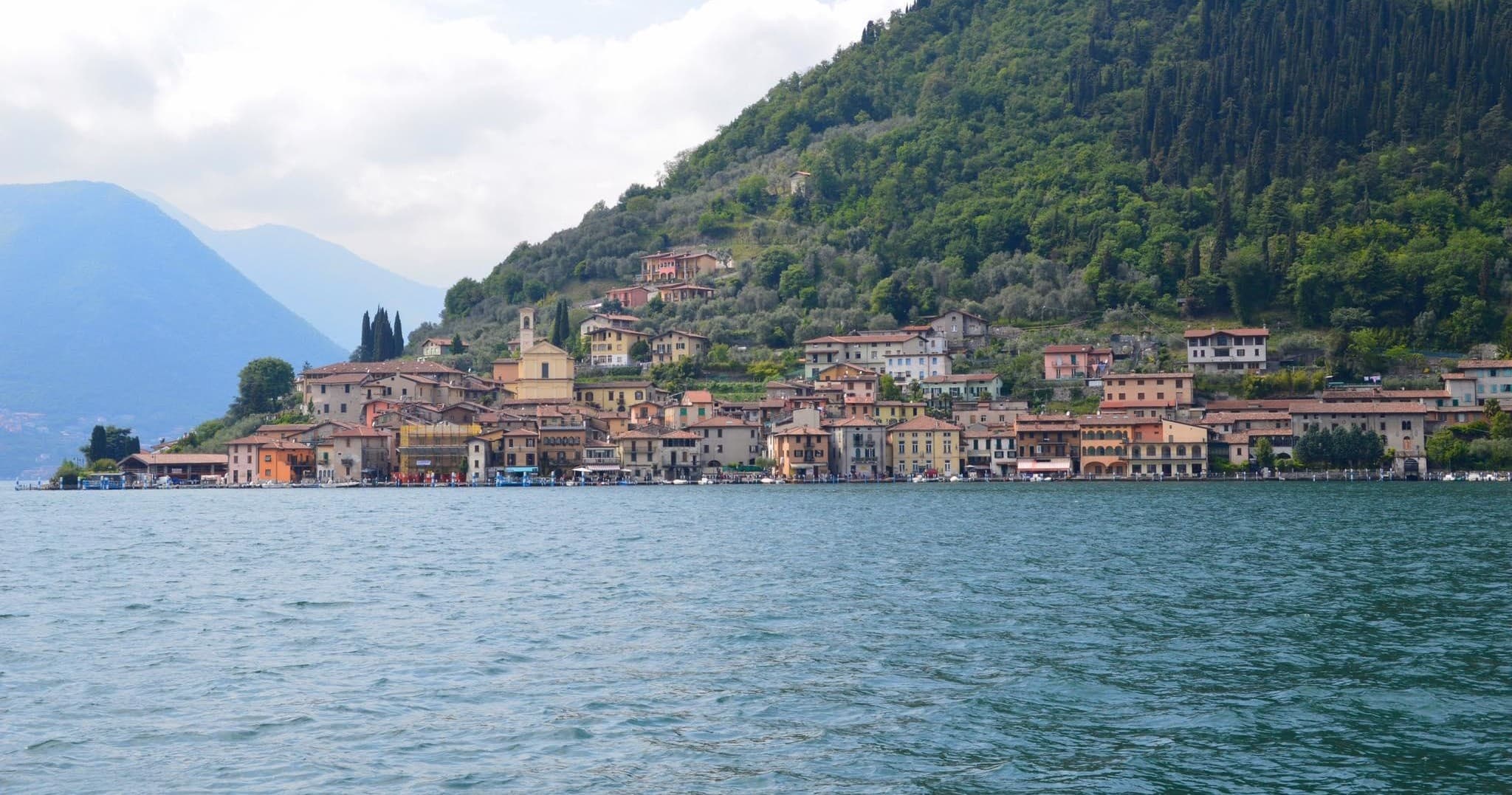 Scenic mountain lake village viewed from water, tranquil shore