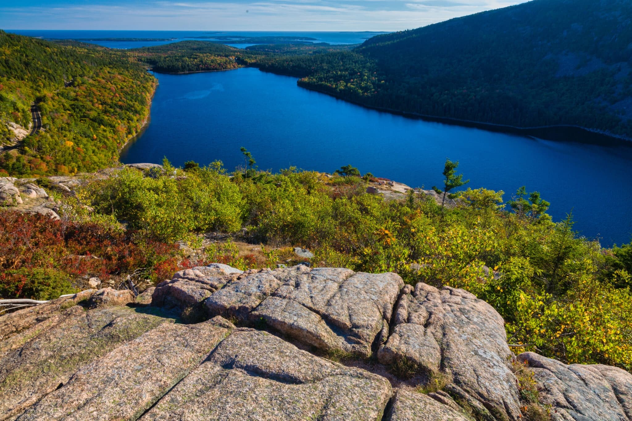Hikers overlooking alpine lake from rocky summit trail