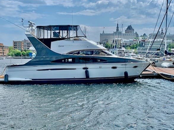 Luxury motor yacht docked in Quebec marina with skyline