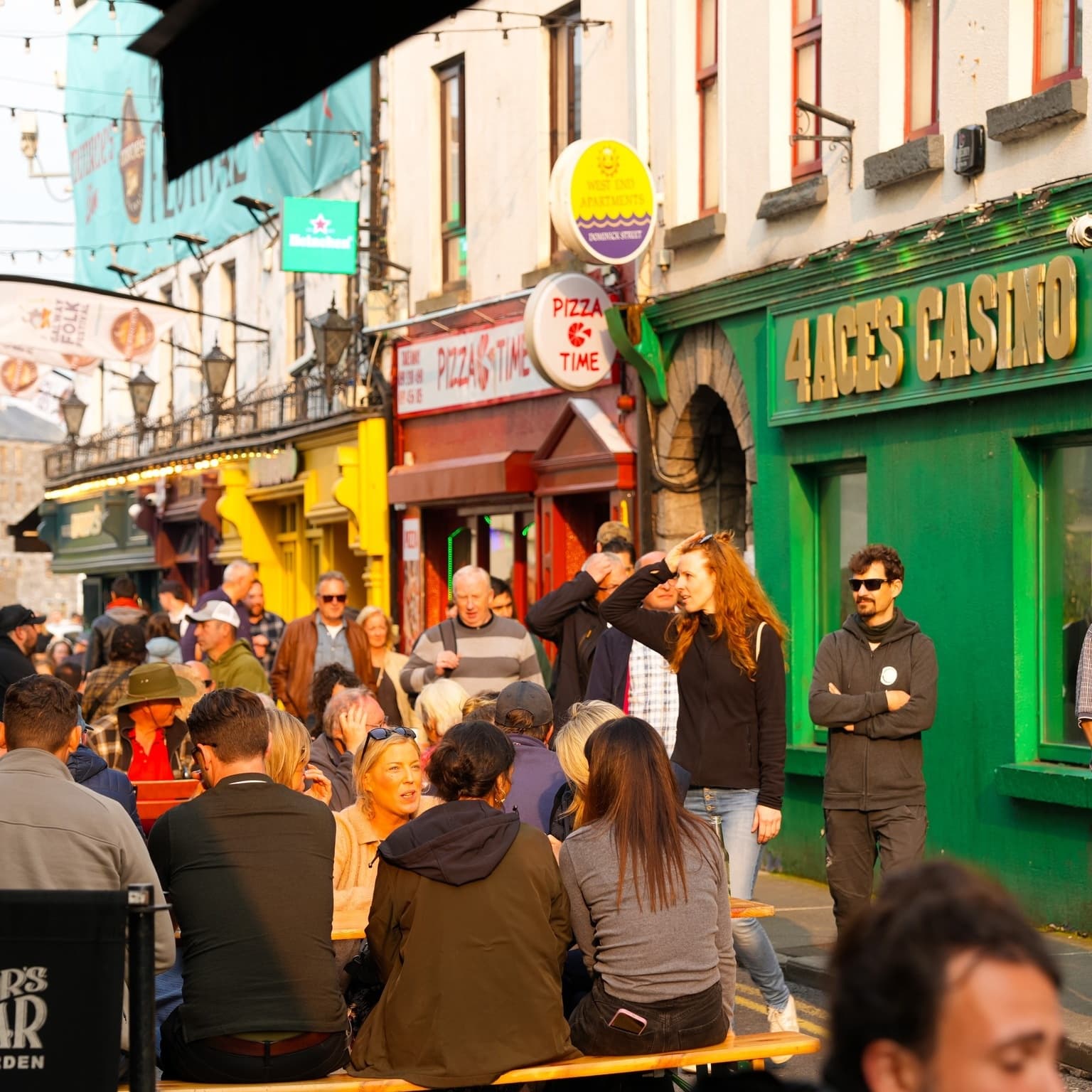 Busy outdoor pub street and festival crowd on colorful Galway lane