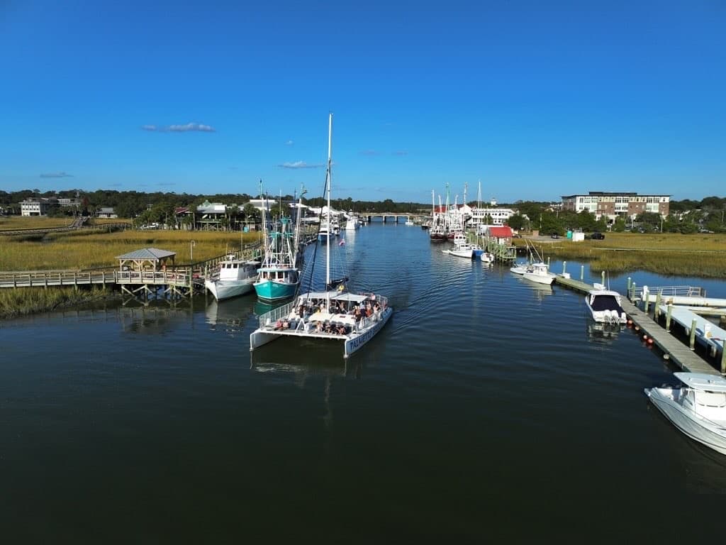 Aerial view of marina channel with cruising tour boats and docks