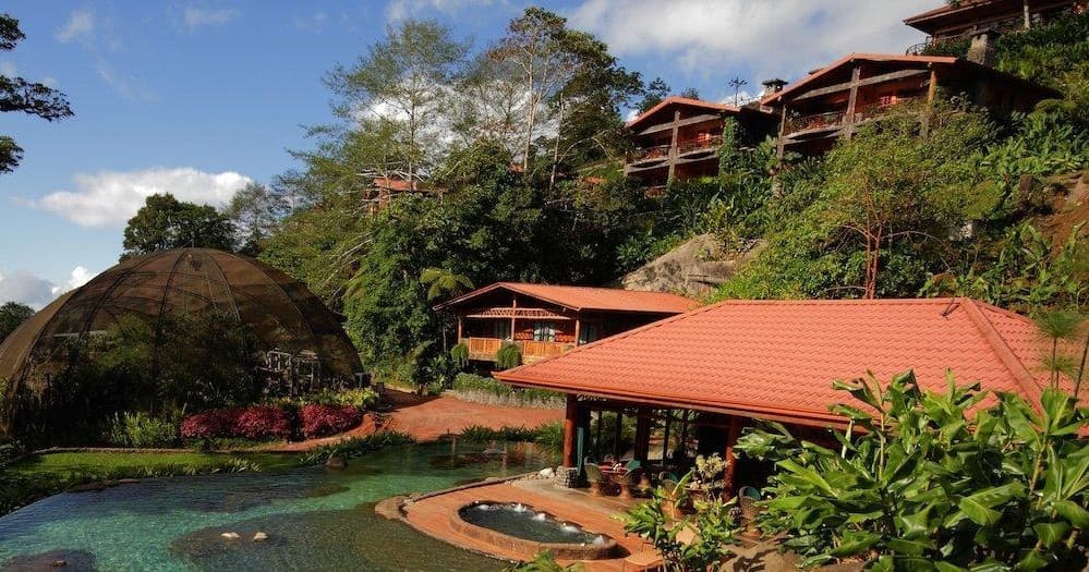 Hillside eco-resort with red roofs overlooking tropical gardens