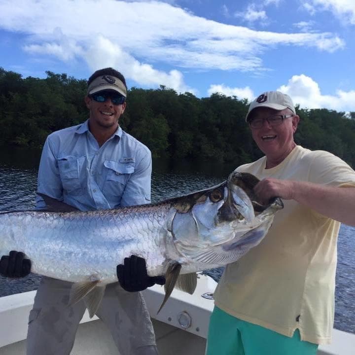 Anglers holding trophy tarpon on deck in Puerto Rico