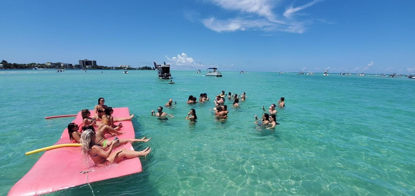 Group paddling and snorkeling from pink platform in shallow turquoise bay