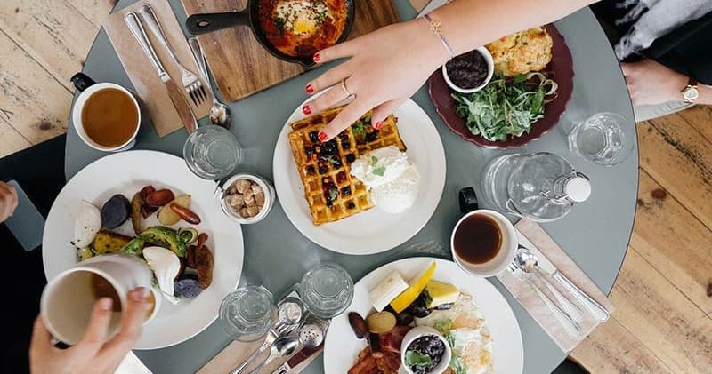 Brunch table with waffles and coffee at indoor cafe meal