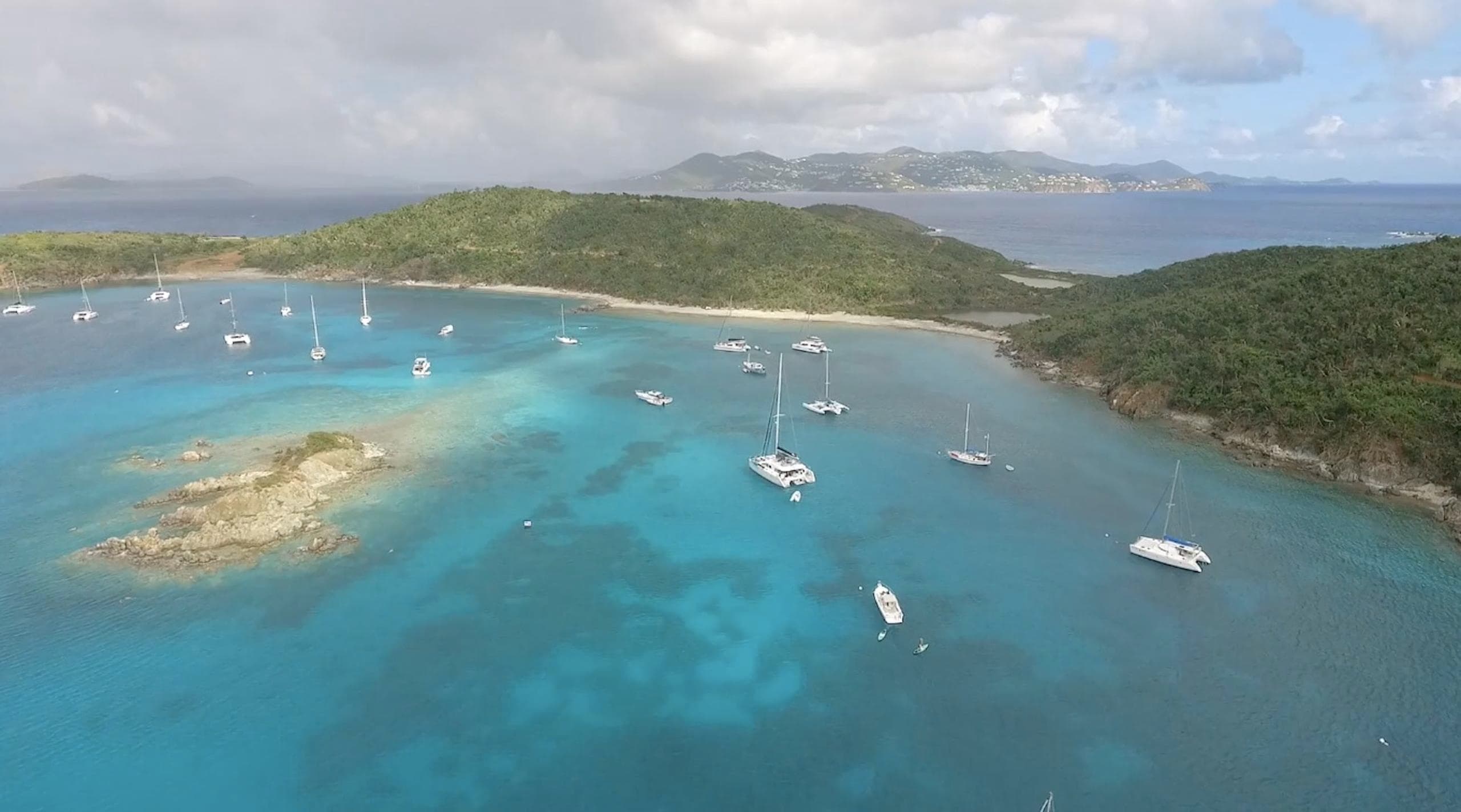 Aerial view of turquoise bay with anchored charter yachts
