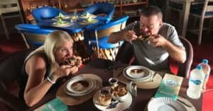 Couple dining at cozy indoor restaurant sampling local dishes