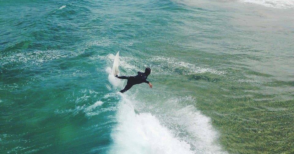 Surfer performing aerial turn over ocean waves off Los Angeles