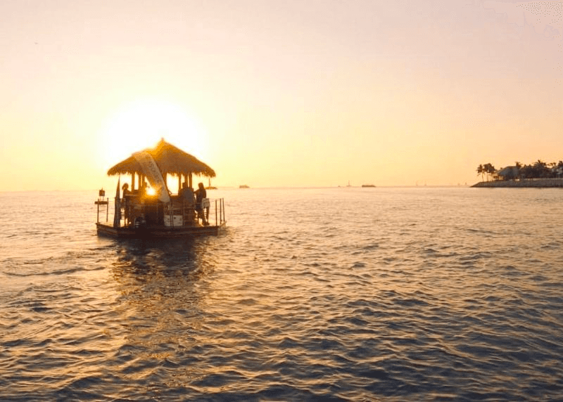 Tiki boat cruise at sunset on Miami bay, scenic floating bar