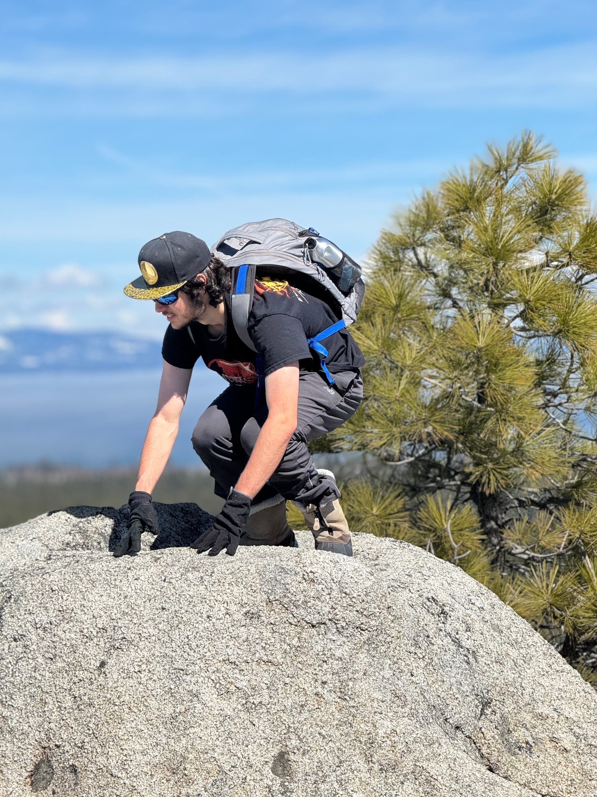 Backcountry hiker surveying alpine lake and pine-covered ridgeline