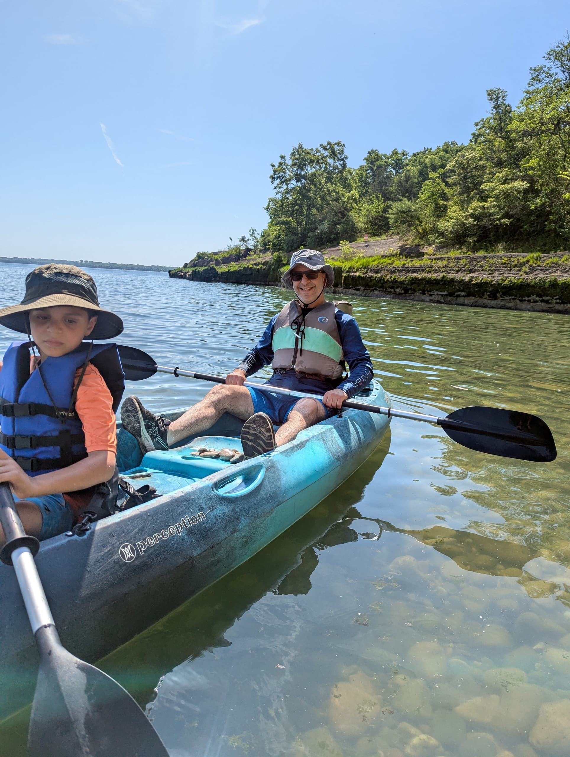 Family kayaking in clear water along Kelleys Island shore
