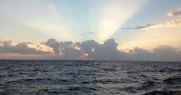Sunrise over open ocean with dramatic sun rays