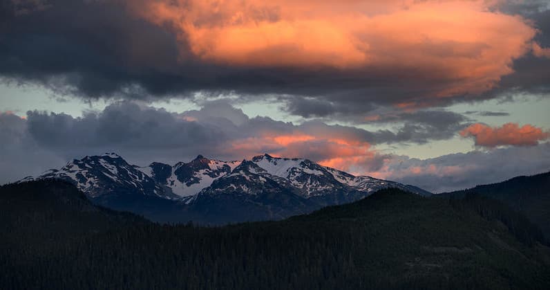 Sunset mountain panorama over alpine peaks and forests