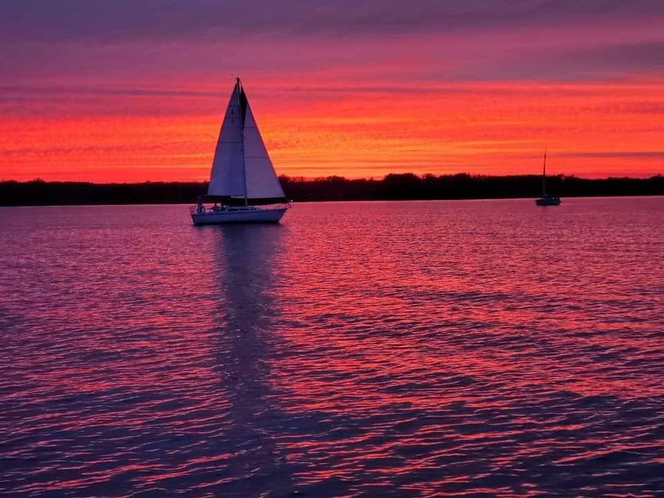 Sailboat silhouetted at vibrant Chicago sunset on Lake Michigan