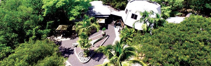Aerial view of riverside mangrove lodge and boat dock in wetlands