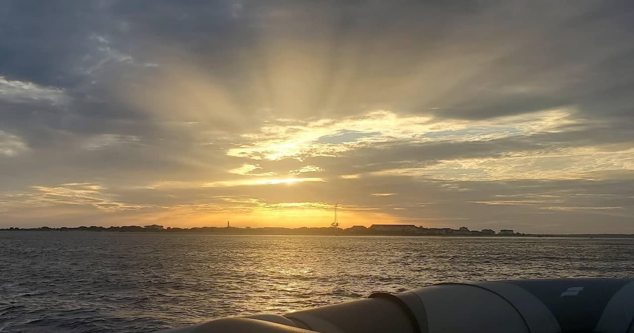 Sunset boat tour on calm coastal waters with distant horizon