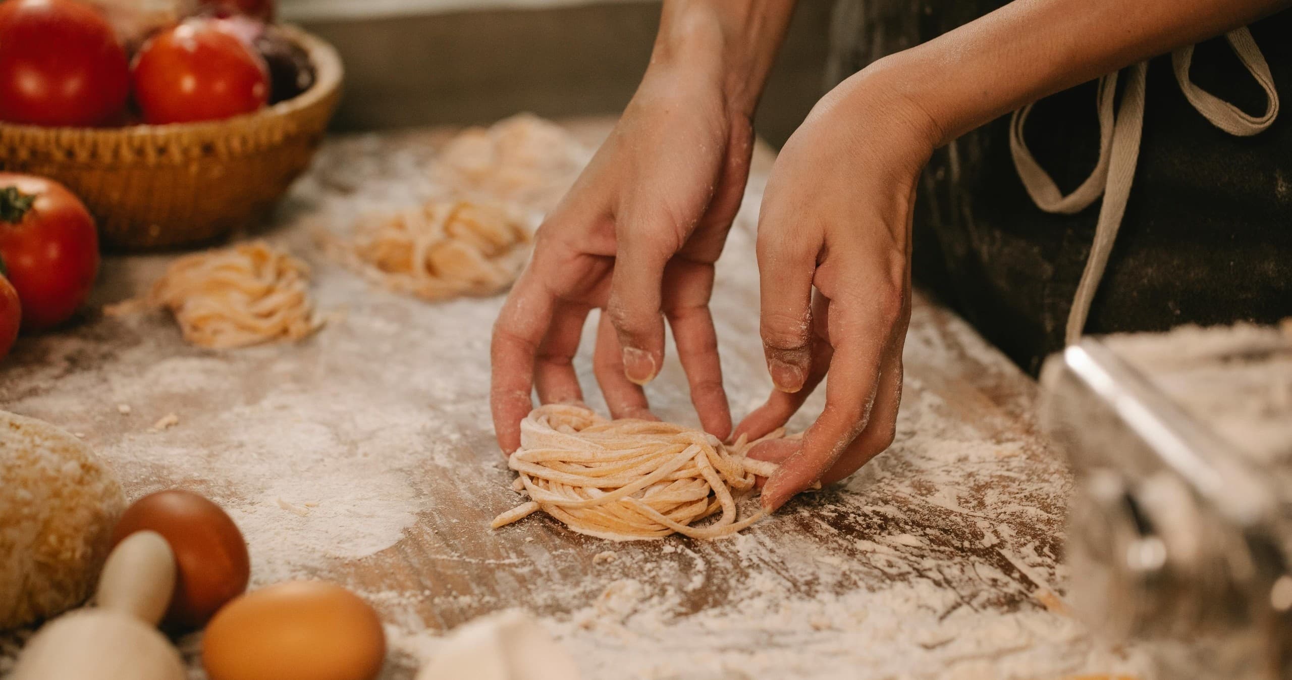 Hands shaping fresh pasta in Florence cooking class kitchen