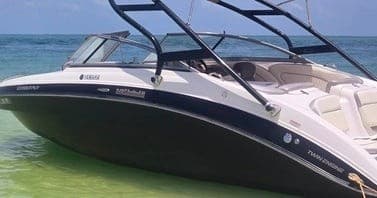 Powerboat anchored at tropical sandbar, passengers relaxing