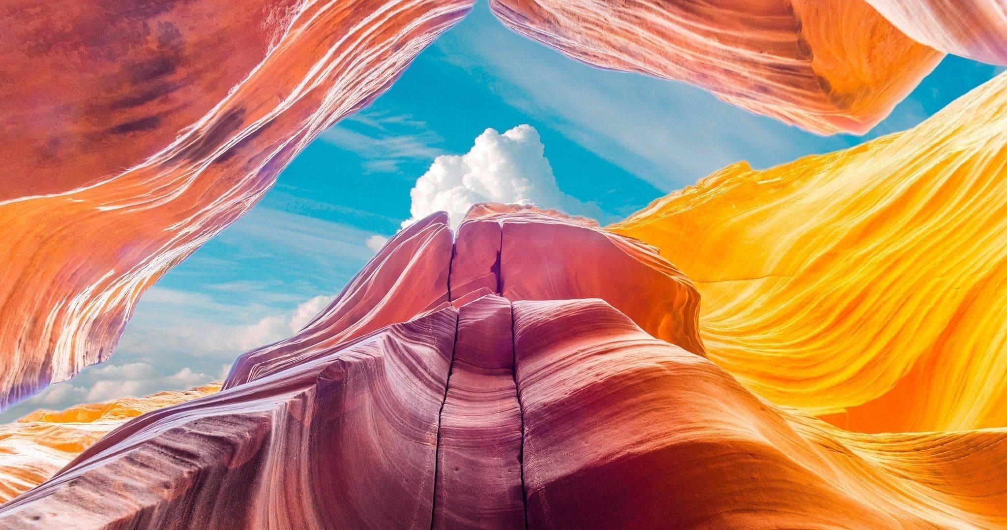 Colorful slot canyon walls with hikers exploring under sky