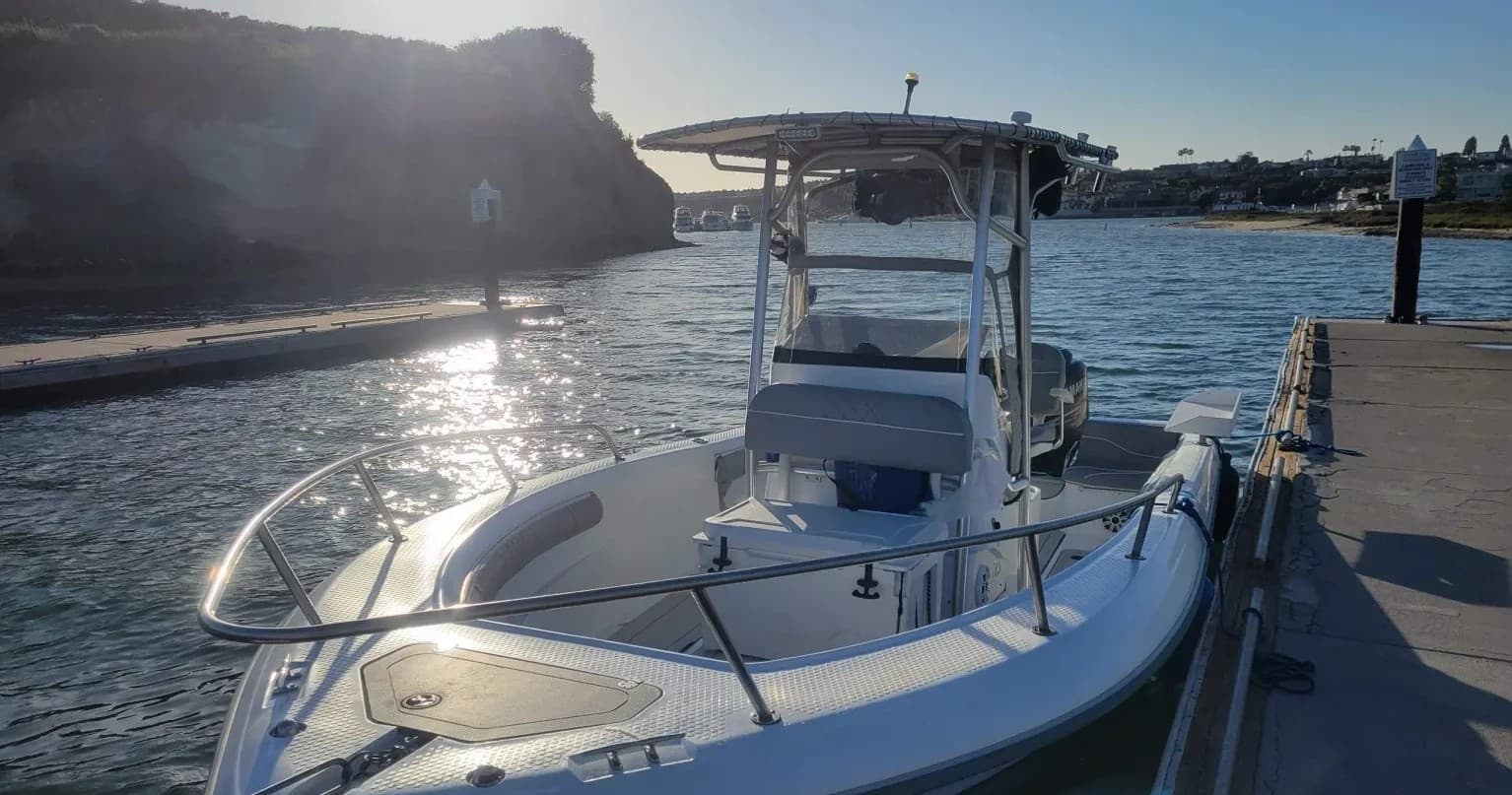 Center console charter boat docked at marina under sunlight