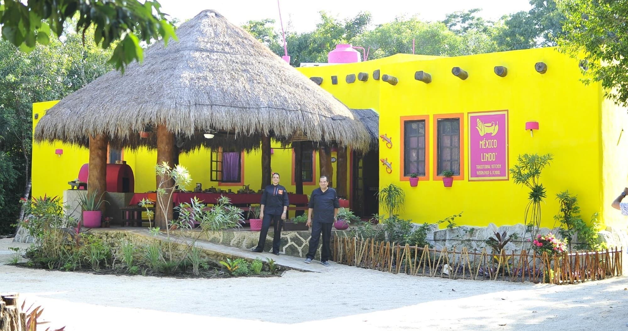 Bright yellow palapa cooking school exterior in Mexican village