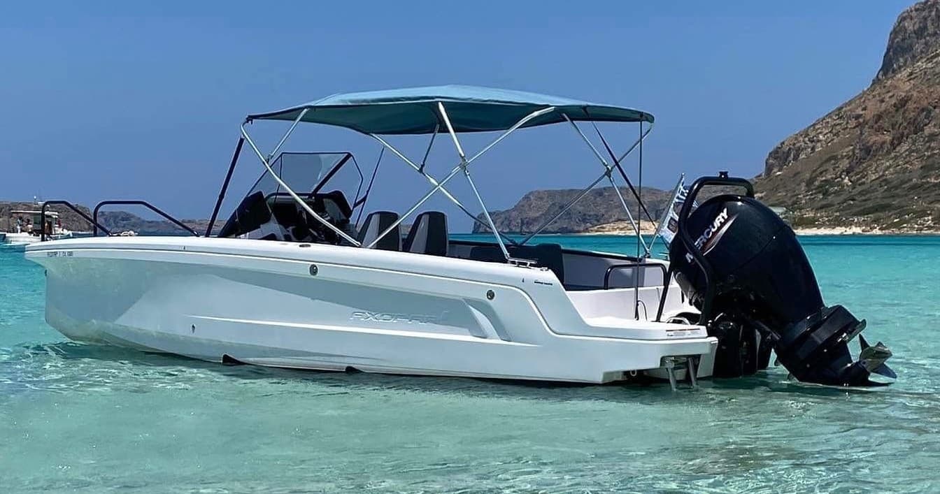 Speedboat gliding over turquoise coastal waters near rocky shoreline