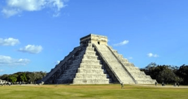 Chichen Itza pyramid at archaeological site under blue sky