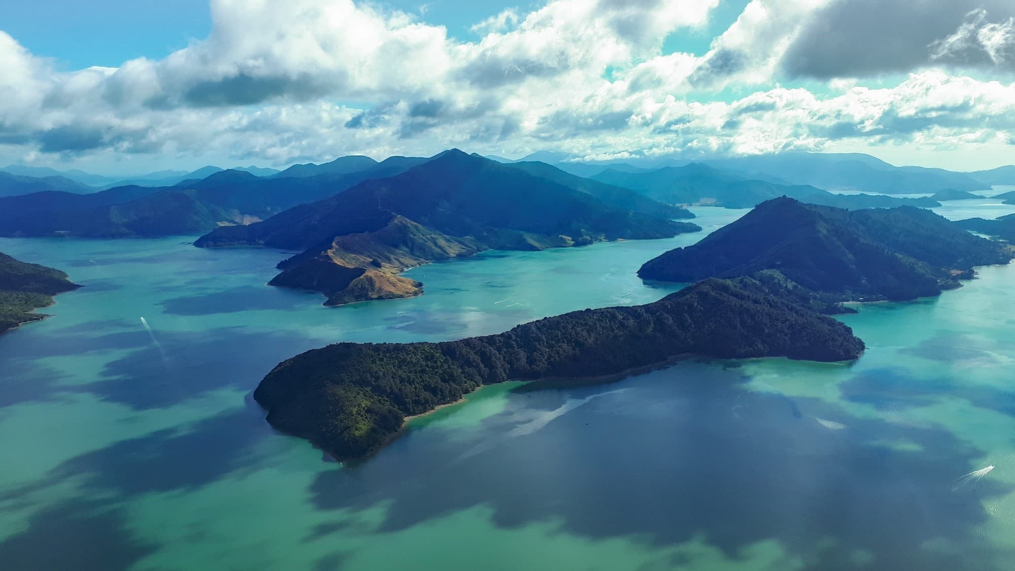 Aerial helicopter soaring above clear coastal bays, scenic flight