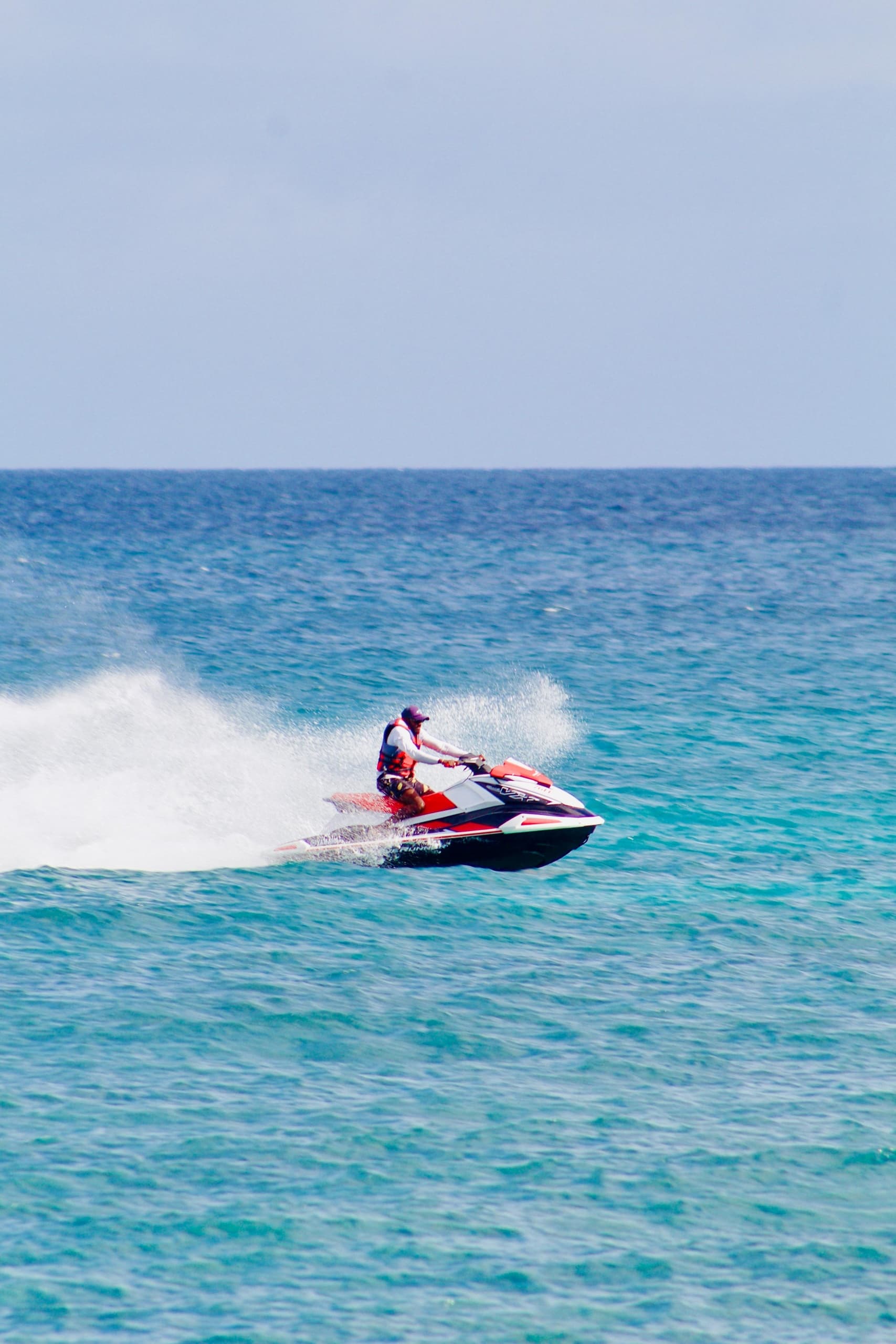 Jet skier carving turquoise waves, high‑speed ocean activity