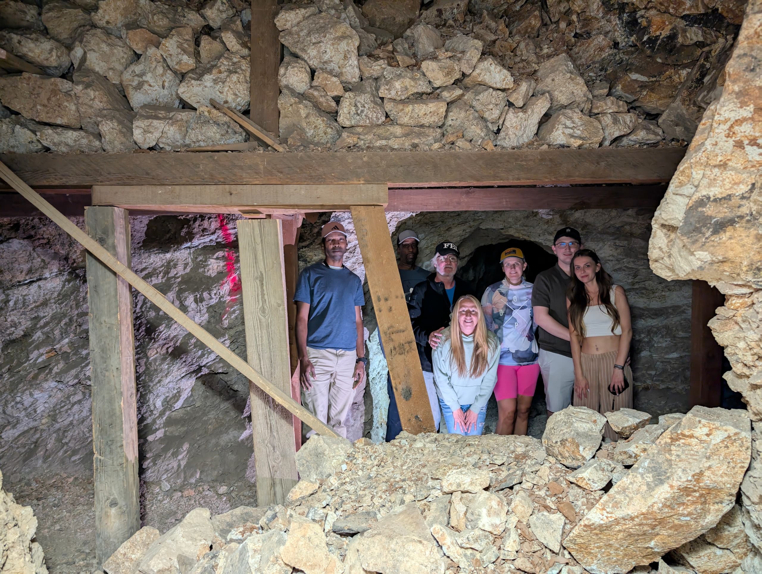 Group exploring old mine tunnel and rock debris on adventure