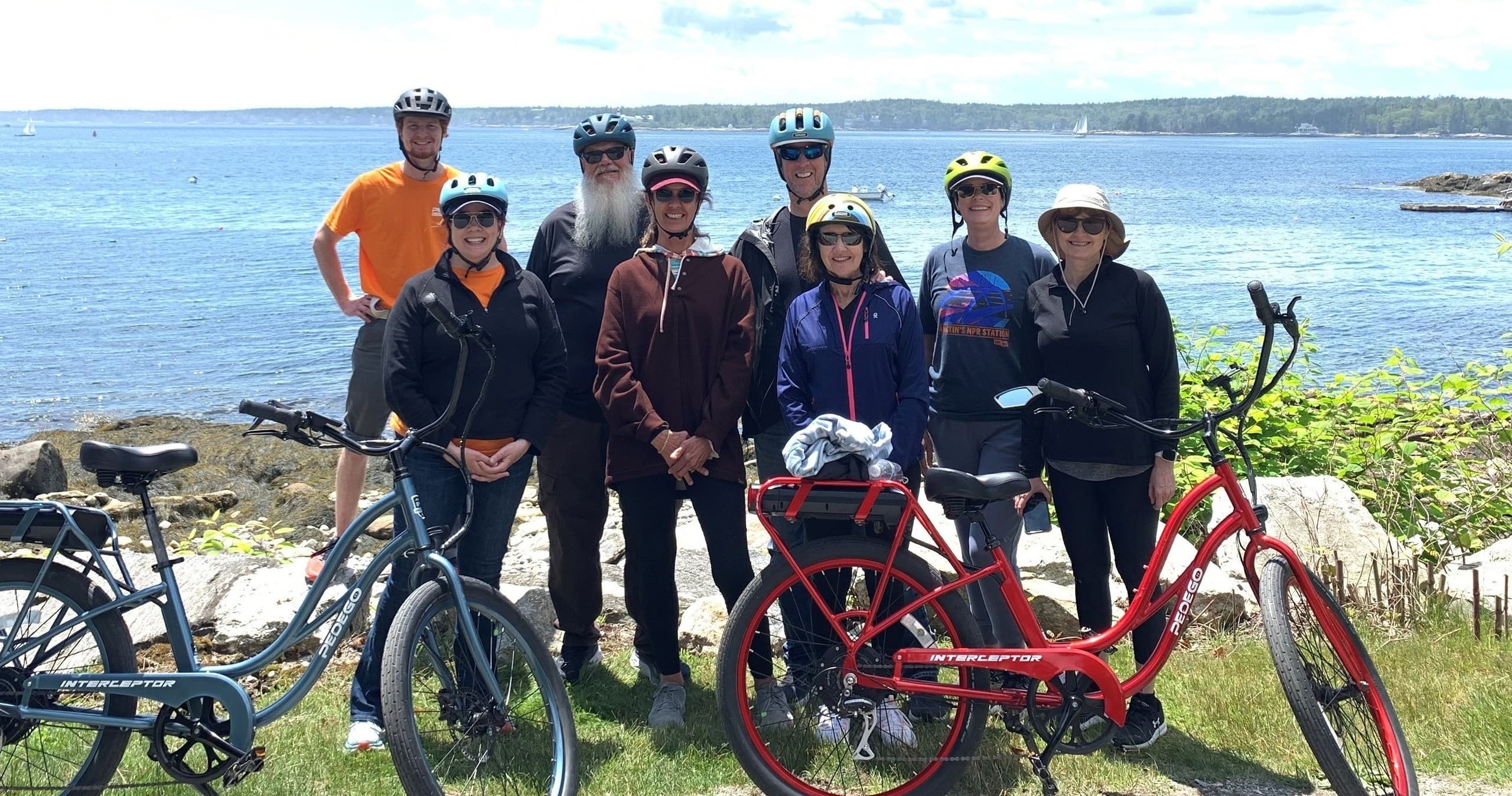Group of cyclists riding a coastal trail with ocean views