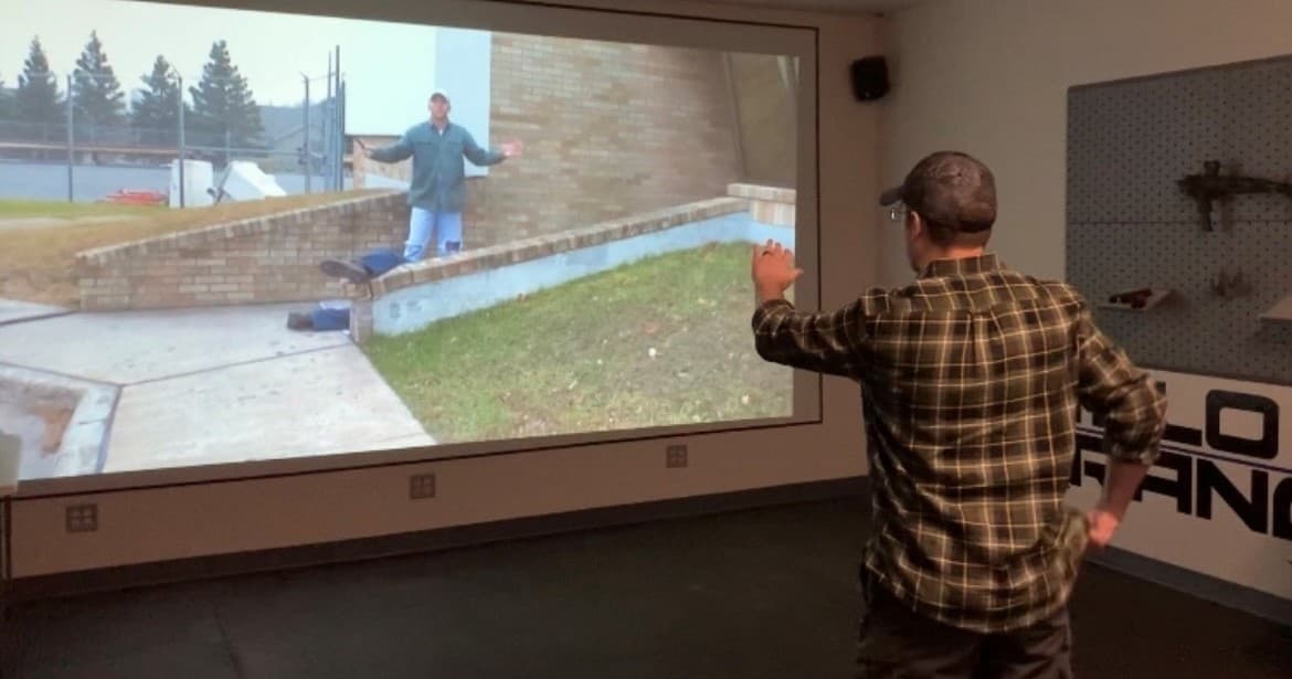 Instructor using virtual shooting simulator in training bay