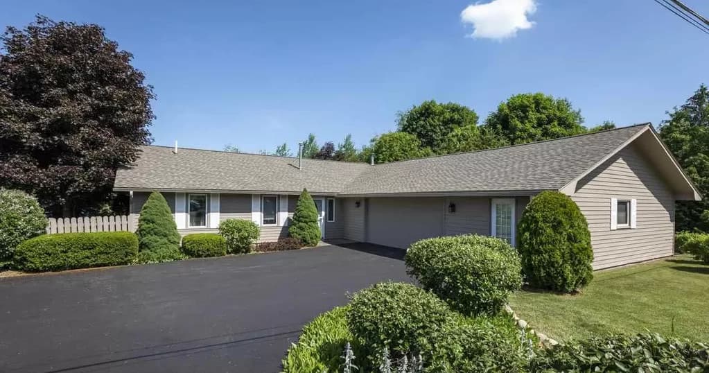 Suburban rental home with landscaped yard in Traverse City curbside