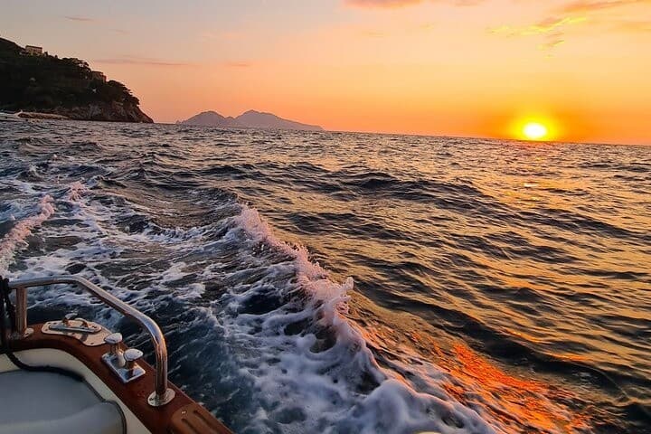 Sunset boat ride with foamy wake and orange sky on Sorrento waters