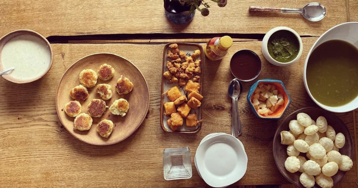 Assorted Indian street-food platter on wooden table for sharing