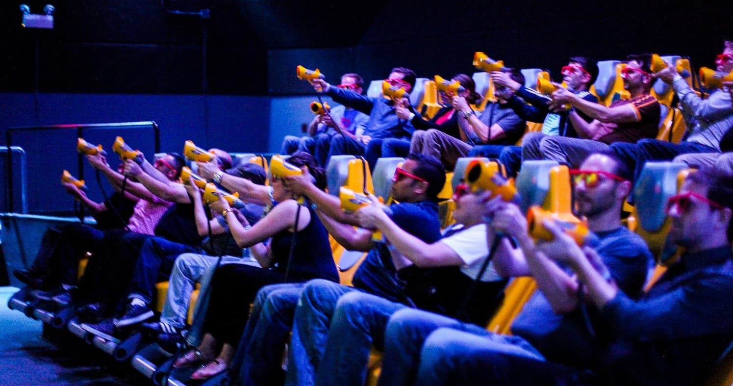 Audience in 4D motion theater pointing interactive blaster guns
