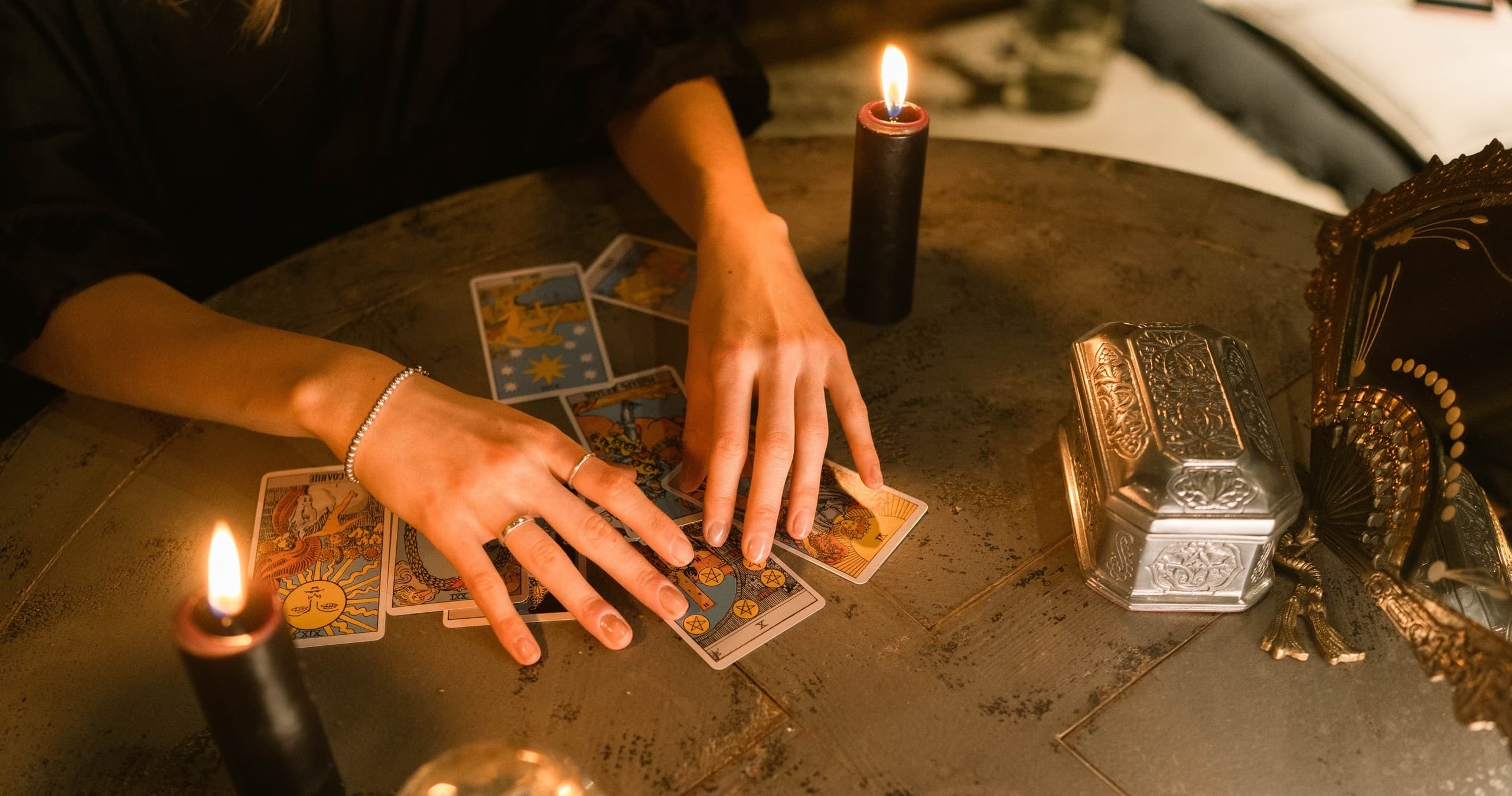 Tarot card reading with candles on wooden table, cozy indoor