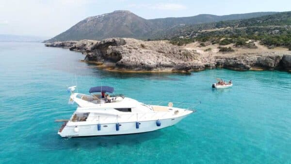 Luxury yacht anchored in shallow turquoise bay near cliffs