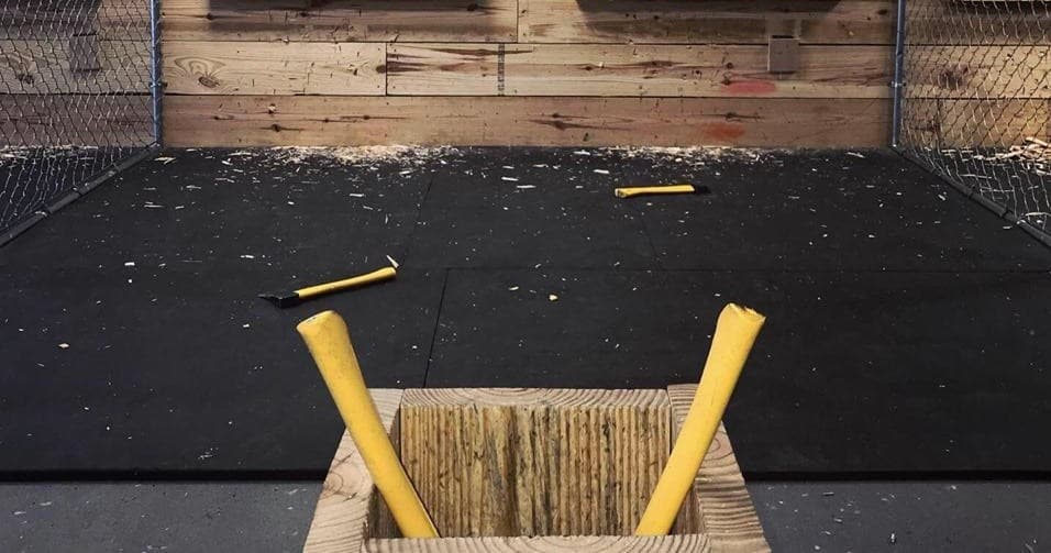 Indoor axe throwing lane with axes in wood block at Ocala venue