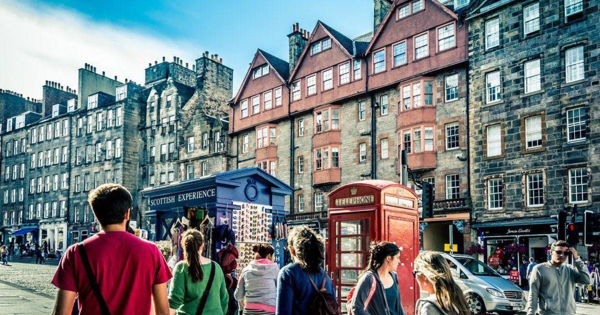 Historic cobbled street with red phone boxes on guided tour
