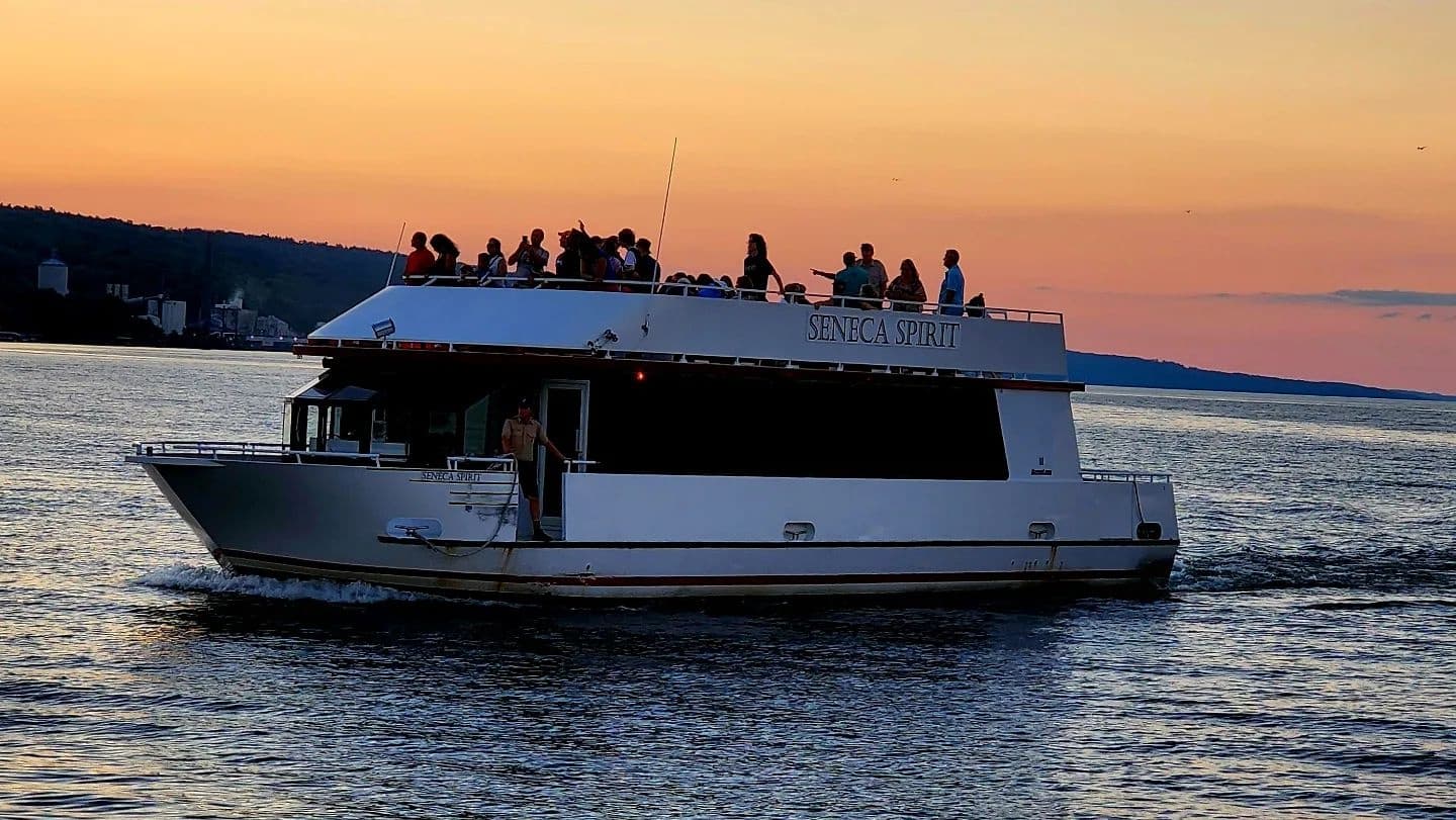 Sunset cruise boat silhouette on Seneca Lake with colorful sky