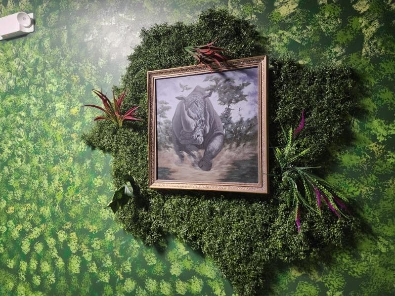 Immersive nature-themed escape room moss wall with rhino art