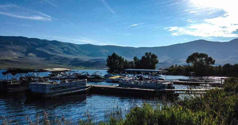 Pontoon boats at dusk in a tranquil mountain lake marina